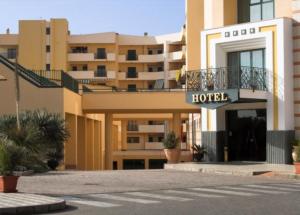 レッジョ・ディ・カラブリアにあるHotel Apanの建物の前にホテルの看板を持つホテル