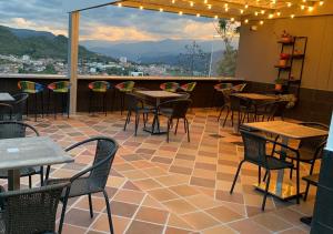 a patio with tables and chairs and a view at Hotel Santorini in San Gil +37 photos