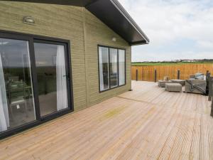a large deck with sliding glass doors on a house at Ramsey in Haverfordwest
