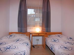 a room with two beds and a table with a window at Gemütliche Ferienwohnung auf Fehmarn in Petersdorf auf Fehmarn