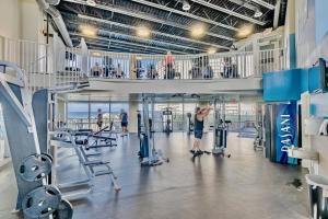 un gimnasio con un hombre haciendo ejercicio en el gimnasio en Laketown Wharf! Sleeps 9 - Resort Beach Condo, Stunning Ocean Views! by Dolce Vita Getaways PCB en Panama City Beach