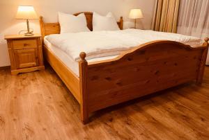 ミッタージルにあるFerienwohnung Ingrid Hörbigerのベッドルーム1室(白いシーツを使用した大きな木製ベッド1台付)