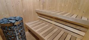 eine Holzbank in einem Zimmer mit Mülleimer in der Unterkunft Wellness Chata Horbek in Vyšné Ružbachy