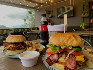 two sandwiches and french fries and a drink on a table at Hotel Santorini in San Gil