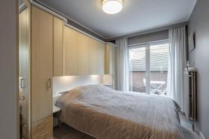 una camera da letto con un letto grande e una finestra di Chez Isabelle a Knokke-Heist