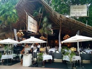 un ristorante con tavoli e ombrelloni e persone in piedi fuori di Stunning 1 Bedroom 1 Bathroom Modern Condo Few Blocks To The Beach And 5th Avenue a Playa del Carmen