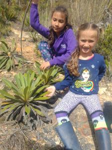 Due ragazze sedute accanto a una pianta di Cabañas camino al cielo a Fúquene
