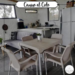 uma cozinha com uma mesa e cadeiras e um sofá em Cabañas camino al cielo em Fúquene