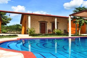 a swimming pool in front of a house at Villas Vallazoo in Valladolid