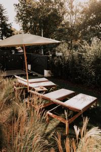 a group of lounge chairs and an umbrella at Chez Brens - Maison d'hôtes à La Hume in Gujan-Mestras