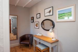 WinscombeにあるThe Woodborough Innの鏡付きの洗面台と椅子が備わる客室です。