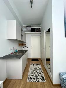 una cocina con armarios blancos y una alfombra en el suelo en Savi Apartment 2 en Pärnu