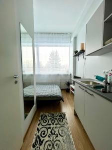 cocina pequeña con ventana y cama en Savi Apartment 2, en Pärnu