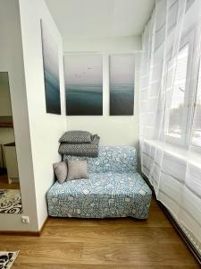 sala de estar con silla y 2 pinturas en Savi Apartment 2, en Pärnu