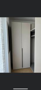 a white cupboard with a refrigerator in a room at Azalea in Cornaiano