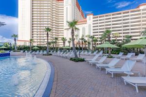 Laketown Wharf! Sleeps 9 - Resort Beach Condo, Stunning Ocean Views! by Dolce Vita Getaways PCB في بنما سيتي بيتش: صف من كراسي الصالة البيضاء بجانب المسبح