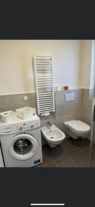 a bathroom with a washing machine and a toilet at Azalea in Cornaiano