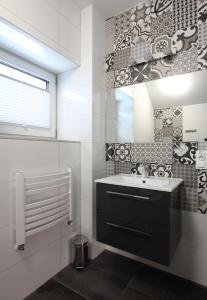 a bathroom with a sink and a mirror at Willa na Plażowej in Węgierska Górka