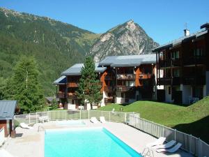 a hotel with a swimming pool in front of a mountain at Charmant 2 pièces près des pistes avec balcon et piscine chauffée - FR-1-464-9 in Pralognan-la-Vanoise +11 photos