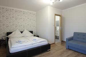 a bedroom with a bed and a blue chair at Willa na Plażowej in Węgierska Górka