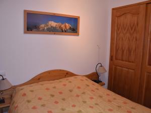 プラローニャン・ラ・ヴァノワーズにあるAppartement Pralognan-la-Vanoise, 3 pièces, 4 personnes - FR-1-464-68のベッドルーム1室(ベッド1台付)が備わります。壁に絵が飾られています。