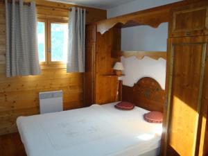 プラローニャン・ラ・ヴァノワーズにあるAppartement Pralognan-la-Vanoise, 3 pièces, 4 personnes - FR-1-464-120の木製の部屋にベッド1台が備わるベッドルーム1室があります。