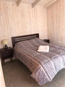 a bedroom with a bed with a pillow on it at Cabaña acogedora en Navidad in Navidad