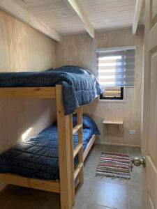 a bedroom with two bunk beds in a tiny house at Cabaña acogedora en Navidad in Navidad