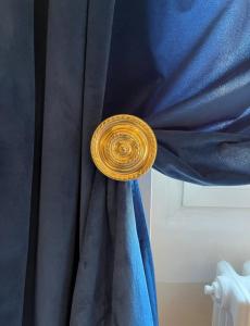 Una cortina azul con un anillo de oro. en Isola suites en Milán
