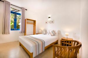 una camera da letto con un letto bianco e una finestra di Urchin Unawatuna a Unawatuna
