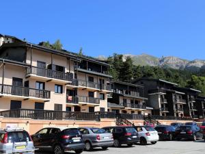a parking lot with cars parked in front of a building at Appartement Aussois, 2 pièces, 4 personnes - FR-1-508-157 in Aussois