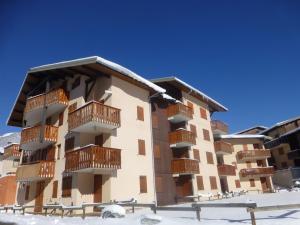 an apartment building with wooden balconies in the snow at Appartement Aussois, 2 pièces, 4 personnes - FR-1-508-148 in Aussois