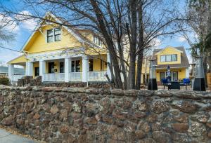 a yellow house with a stone retaining wall at Bespoke Inn Flagstaff in Flagstaff