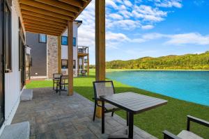 un patio con mesa y sillas junto a un lago en Owl's Nest Resort, en Thornton