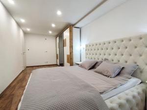 1 dormitorio con 1 cama grande y cabecero grande en Stara Pošta Apartment 8, en Grosuplje