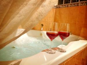 - Dos copas de vino tinto en la bañera en Romantic Getaway PR - Stay & Spa, en Arecibo