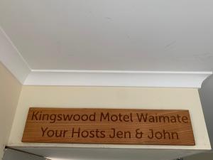 un cartel de madera en el techo de una habitación en Kingswood Motel, en Waimate