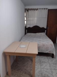 a table and a bed in a room with a bed sidx sidx sidx at Scotti's Suítes in Capão da Canoa