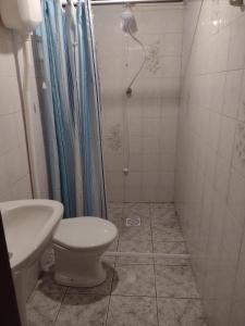 uma casa de banho com um WC e um chuveiro em Scotti's Suítes em Capão da Canoa