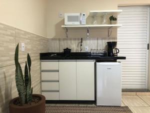 a kitchen with white cabinets and a black counter top at Weisse Rose Haus in Pomerode