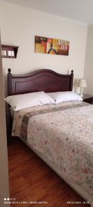 a bedroom with a bed with a wooden headboard at Departamento Full 3D 2B Cerca de Playas en Arica in Arica