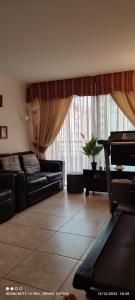 a living room with black furniture and a large window at Departamento Full 3D 2B Cerca de Playas en Arica in Arica