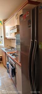 a kitchen with a stainless steel refrigerator at Departamento Full 3D 2B Cerca de Playas en Arica in Arica