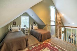 a attic bedroom with two beds and a balcony at Hot Tub and Wooded Views Lakefront Blue Eye Cottage in Blue Eye