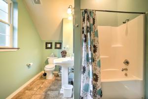 a bathroom with a shower and a sink and a toilet at Hot Tub and Wooded Views Lakefront Blue Eye Cottage in Blue Eye +19 photos