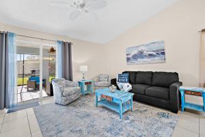a living room with a couch and chairs and a table at Seaside Bliss - Duplex Oasis with Heated Pool Steps to Paradise Beach! in Melbourne
