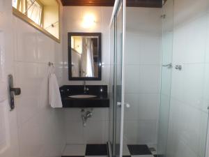 a bathroom with a sink and a glass shower at Pousada Hotel Praia dos Anjos in Arraial do Cabo