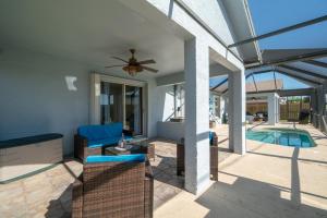 a patio with a couch and a ceiling fan at Serene Seaside Retreat - Dog friendly - 2BR Townhouse with Heated Pool Steps to Paradise Beach! in Melbourne