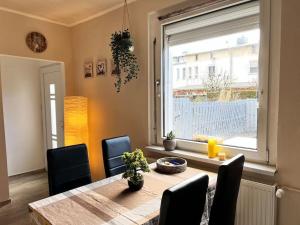 ein Esszimmer mit einem Tisch, Stühlen und einem Fenster in der Unterkunft Gemütliches Reihenhaus mit Terrasse in Magdeburg