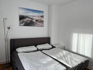 ein Bett in einem Schlafzimmer mit einem Bild an der Wand in der Unterkunft Gemütliches Reihenhaus mit Terrasse in Magdeburg